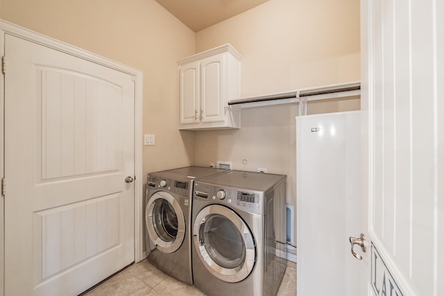 laundry area featuring washer and dryer, cabinet space, and light tile patterned floors