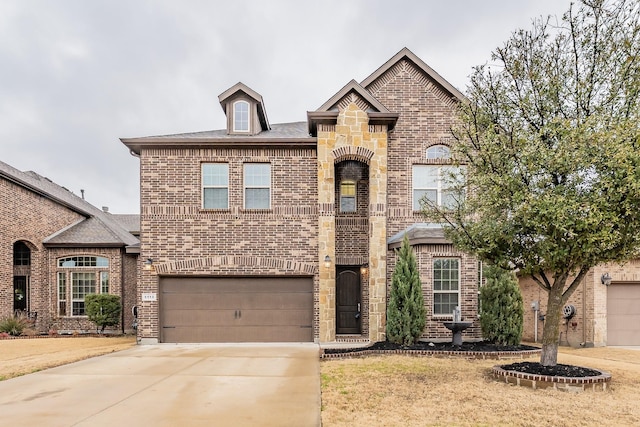 french country home featuring brick siding, stone siding, an attached garage, and concrete driveway