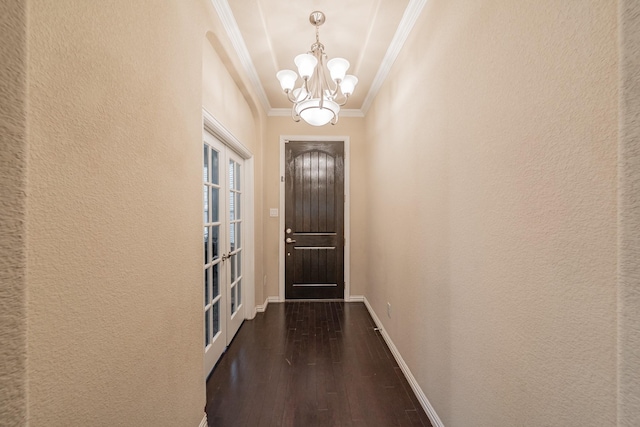 doorway with dark wood-style floors, baseboards, an inviting chandelier, crown molding, and a textured wall