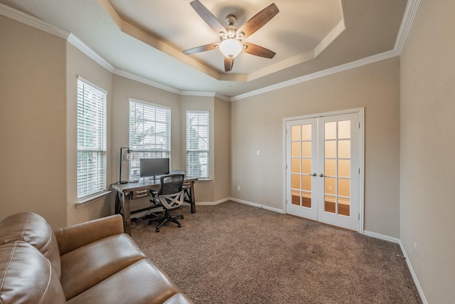 carpeted office space with baseboards, ornamental molding, french doors, a raised ceiling, and a ceiling fan