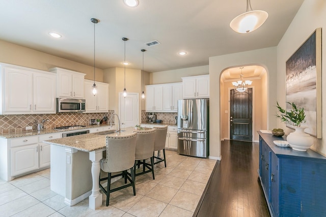 5113 Vieques Ln, Fort Worth, TX 76244 - kitchen featuring appliances with stainless steel finishes, a sink, white cabinetry, arched walkways, and recessed lighting