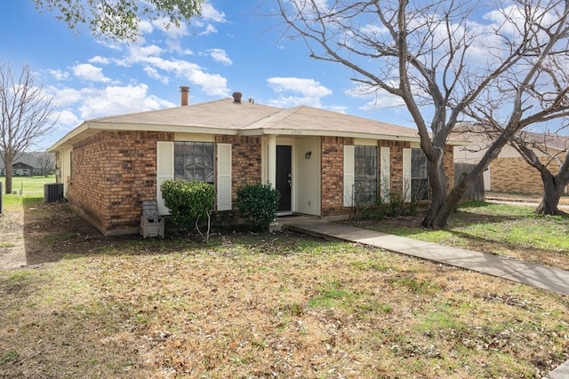 ranch-style house with brick siding, central air condition unit, and a front yard