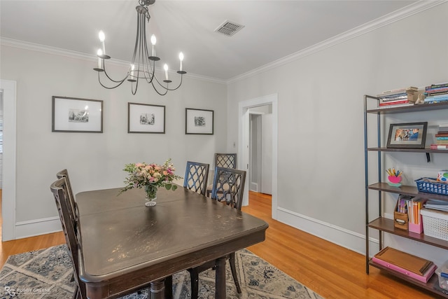 dining room with baseboards, visible vents, light wood finished floors, and ornamental molding