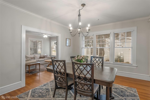 dining room with a chandelier, baseboards, wood finished floors, and ornamental molding