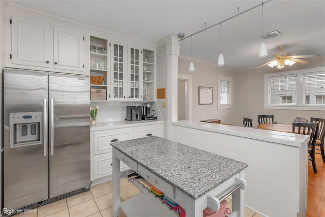 kitchen with visible vents, a kitchen island, open shelves, a peninsula, and stainless steel fridge