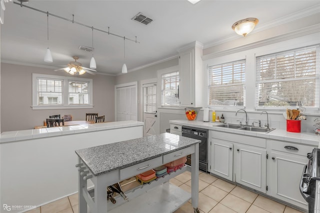 kitchen with a sink, tile counters, dishwasher, crown molding, and range