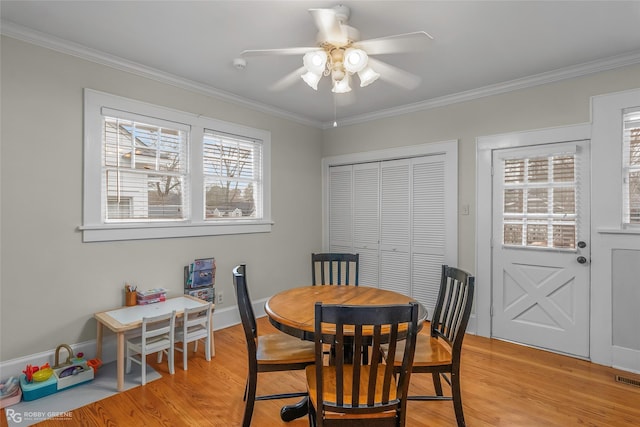 dining area with ceiling fan, light wood-style floors, and ornamental molding