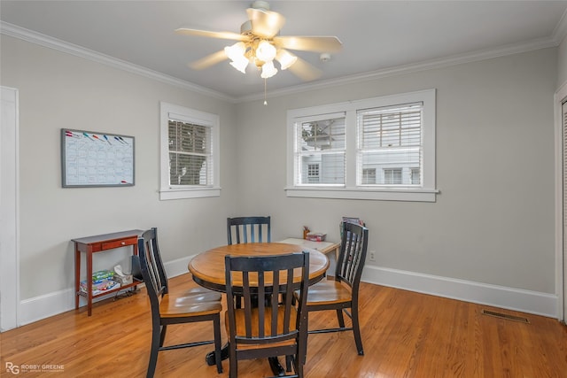 dining space with visible vents, light wood-type flooring, baseboards, and ornamental molding