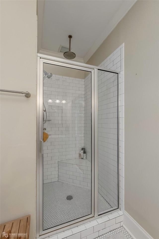 full bath featuring a stall shower, baseboards, and ornamental molding