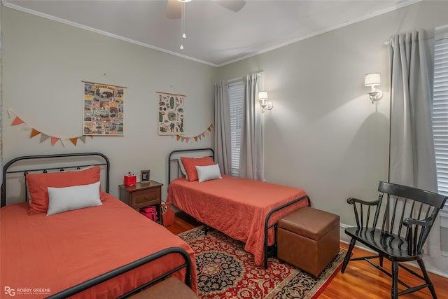 bedroom featuring a ceiling fan, wood finished floors, and crown molding