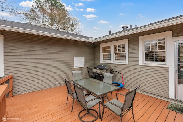 wooden deck with outdoor dining space and area for grilling