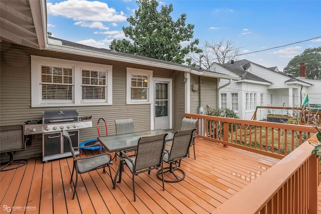 wooden deck featuring outdoor dining area and a grill