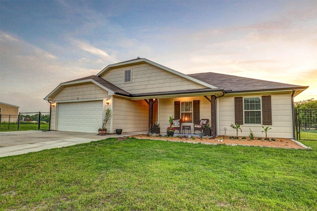 view of front of home featuring driveway, an attached garage, a front lawn, and fence