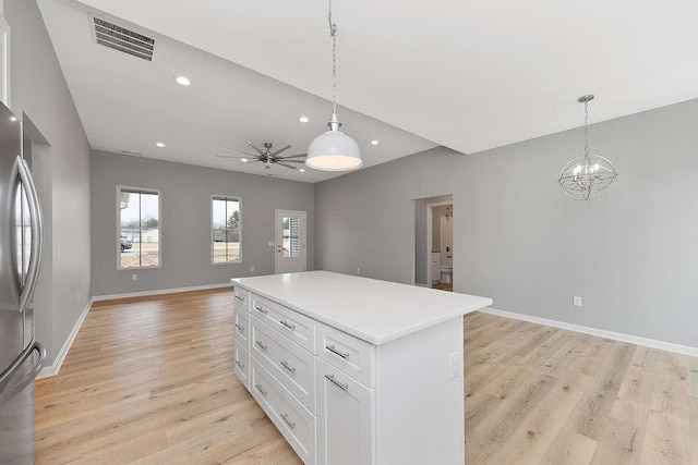 kitchen with visible vents, light wood-type flooring, freestanding refrigerator, white cabinetry, and open floor plan