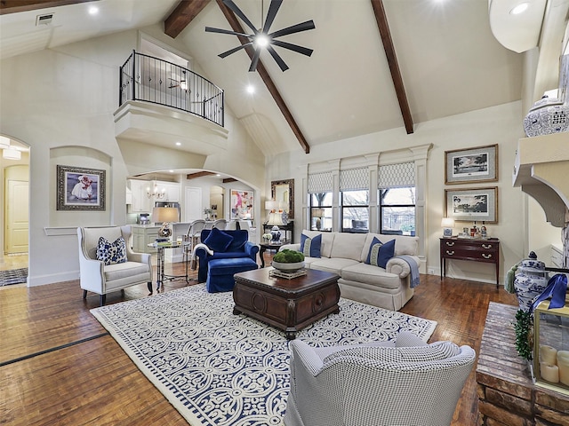 living area featuring hardwood / wood-style floors, an inviting chandelier, arched walkways, and high vaulted ceiling