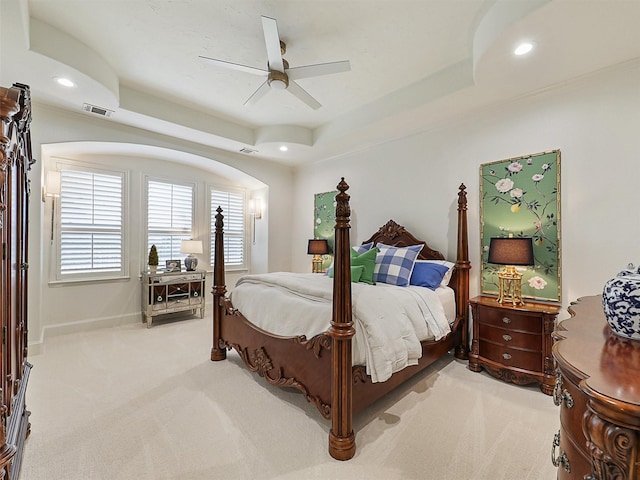 bedroom featuring a tray ceiling, carpet flooring, and visible vents