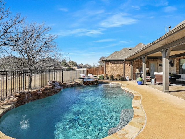 view of swimming pool featuring a patio, a pool with connected hot tub, and a fenced backyard