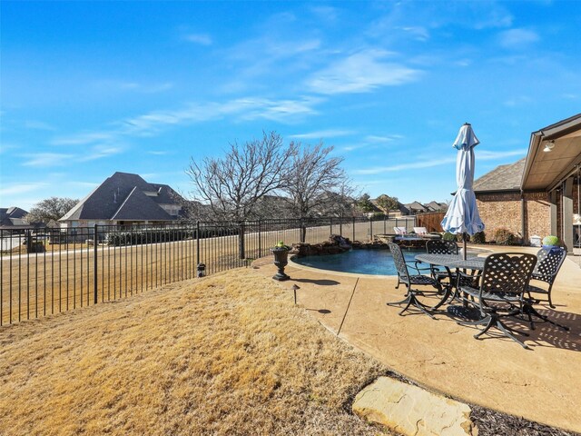 view of yard featuring a patio area, outdoor dining space, and a fenced backyard