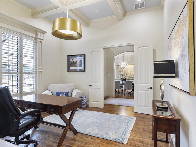 home office featuring arched walkways, visible vents, beam ceiling, and wood finished floors