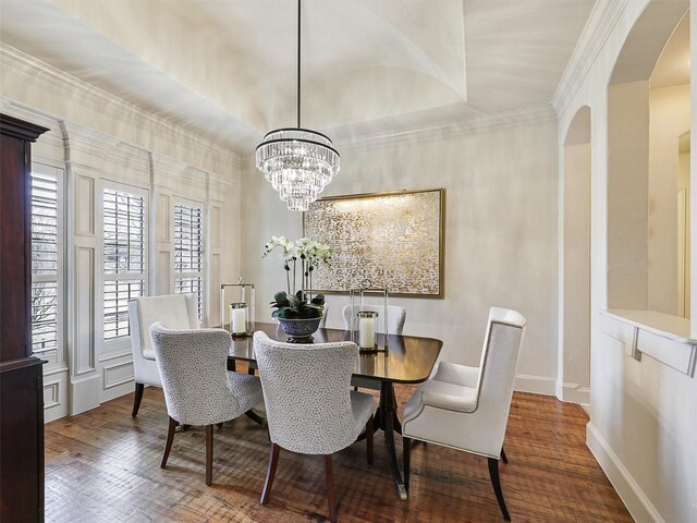 dining room with wood finished floors, baseboards, an inviting chandelier, arched walkways, and crown molding