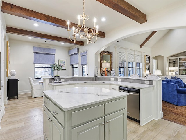 kitchen with a sink, stainless steel dishwasher, open floor plan, a center island, and arched walkways