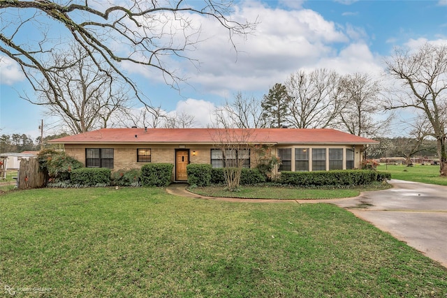 ranch-style home with brick siding, a front yard, and fence