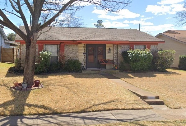 single story home featuring a front lawn and a shingled roof