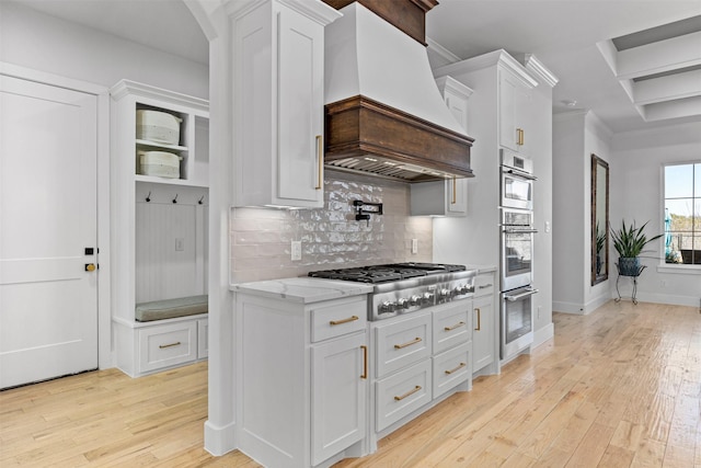 kitchen featuring light wood-type flooring, white cabinetry, custom exhaust hood, and stainless steel gas cooktop