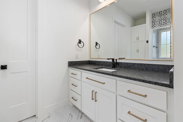 bathroom featuring marble finish floor, vanity, and baseboards