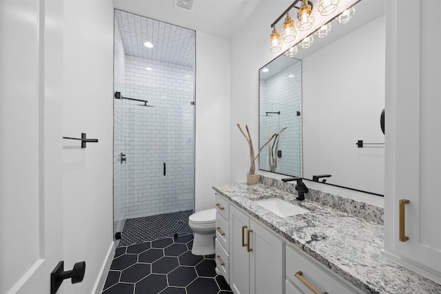 bathroom featuring toilet, a stall shower, tile patterned flooring, baseboards, and vanity