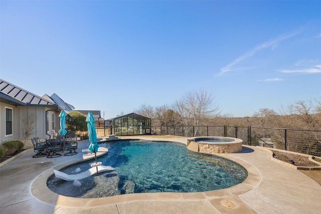 view of pool with outdoor dining area, fence, a pool with connected hot tub, and a patio area