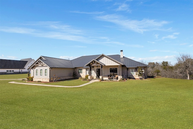 view of front of property with a standing seam roof, a front yard, and metal roof