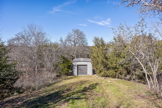 view of yard with a shed, a detached garage, and an outdoor structure