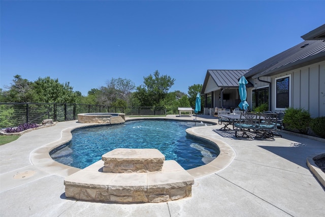 view of swimming pool featuring fence, a patio, and a pool with connected hot tub