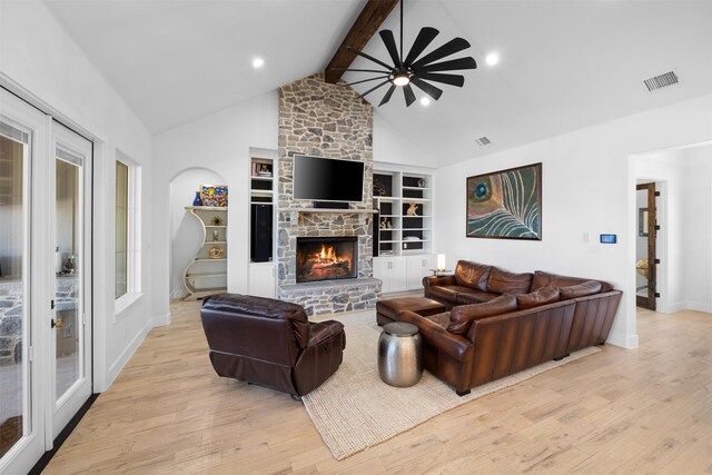 living room featuring a ceiling fan, visible vents, baseboards, light wood finished floors, and vaulted ceiling with beams