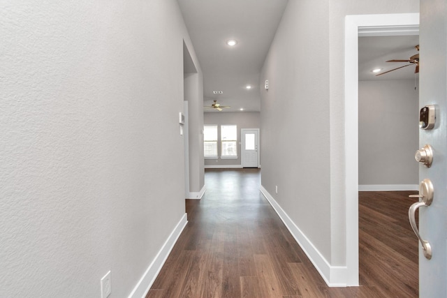 hallway featuring dark wood-type flooring, recessed lighting, and baseboards