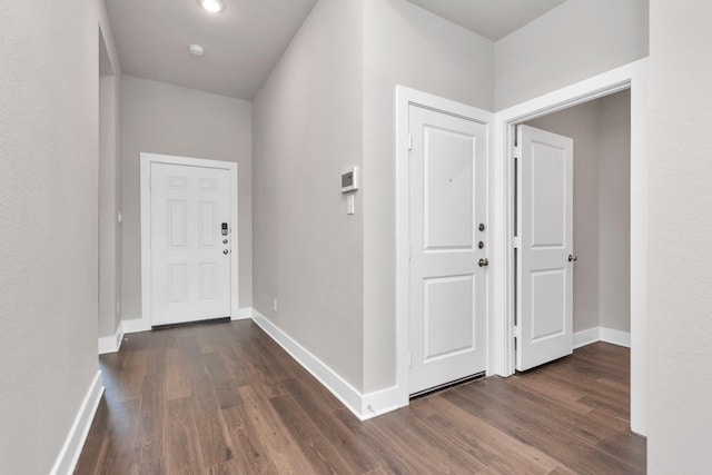 entryway featuring dark wood-type flooring and baseboards