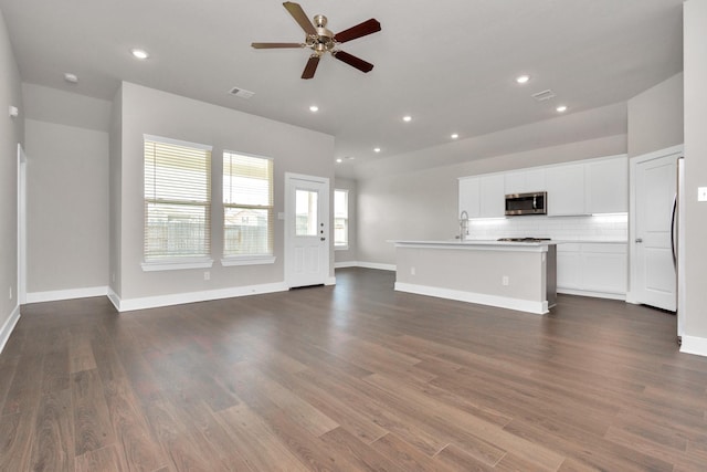 unfurnished living room with dark wood finished floors, recessed lighting, a ceiling fan, and baseboards