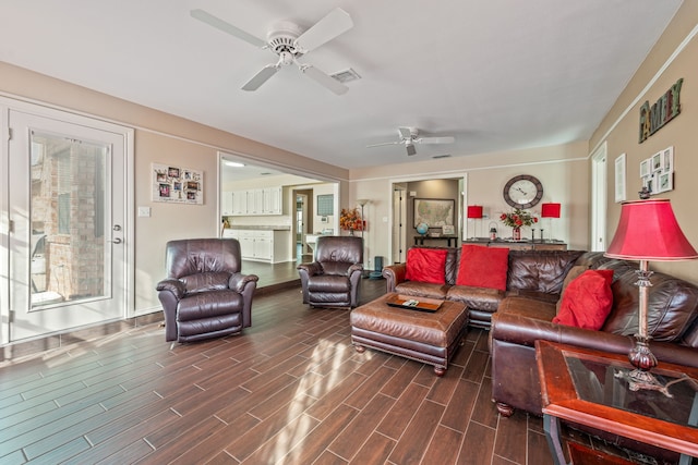 living room featuring wood finish floors, visible vents, and ceiling fan