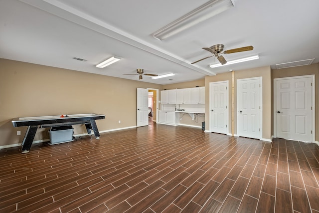 interior space with visible vents, baseboards, dark wood finished floors, and a ceiling fan