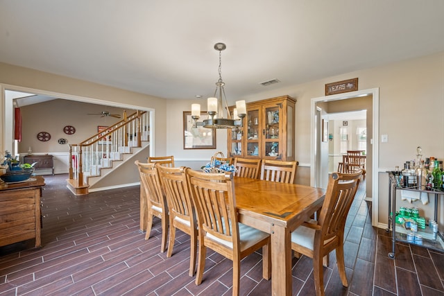 dining room with stairs, visible vents, baseboards, and wood tiled floor