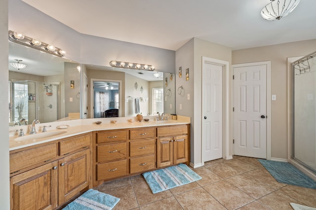 full bath with tile patterned flooring, a shower stall, double vanity, and a sink