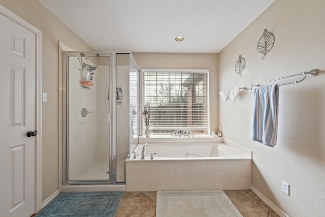 full bath with tile patterned floors, baseboards, a garden tub, and a stall shower