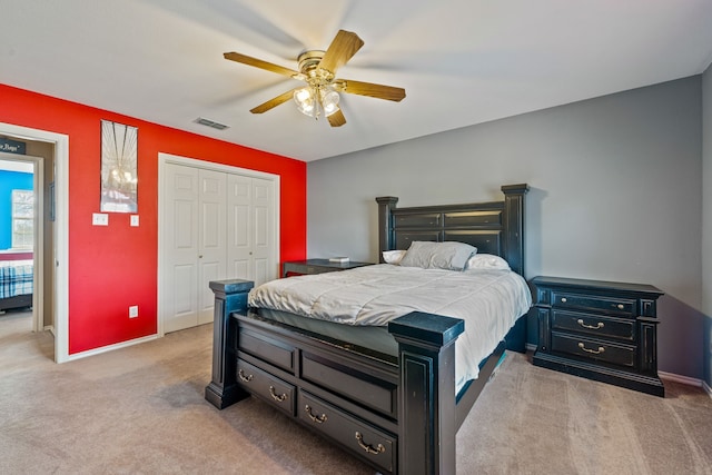 bedroom with visible vents, baseboards, ceiling fan, carpet flooring, and a closet