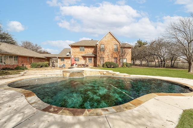 pool featuring a patio, a yard, and fence