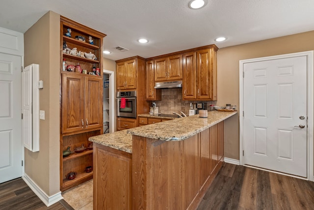 kitchen with visible vents, light stone countertops, under cabinet range hood, stainless steel oven, and open shelves