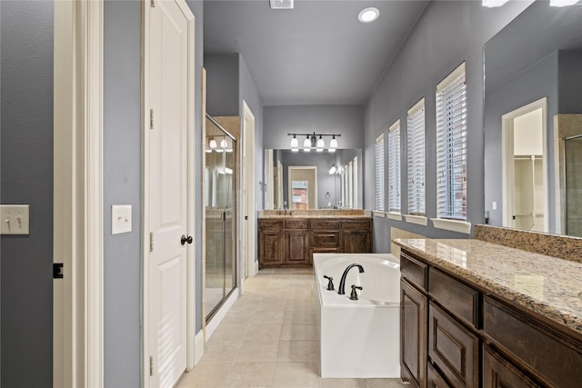 full bathroom with vanity, a garden tub, a stall shower, and tile patterned flooring