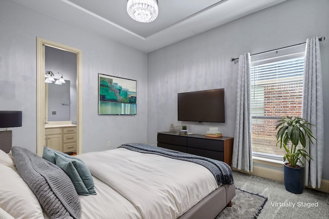 bedroom featuring carpet floors, a notable chandelier, and ensuite bath