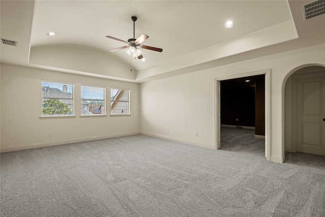 empty room featuring visible vents, baseboards, light colored carpet, and vaulted ceiling