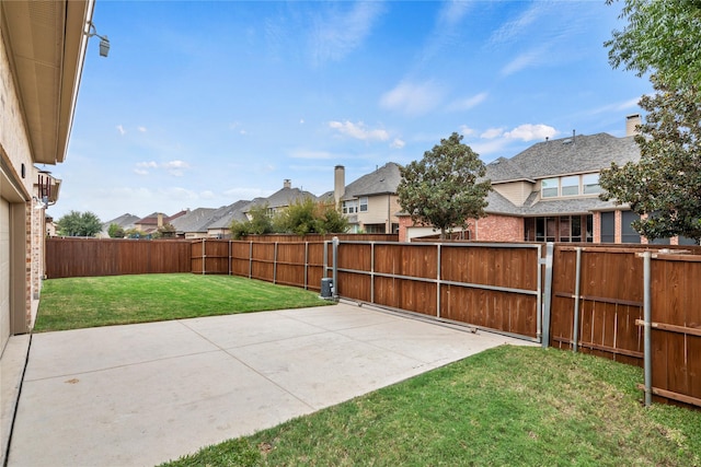 view of yard featuring a residential view, a fenced backyard, and a patio area